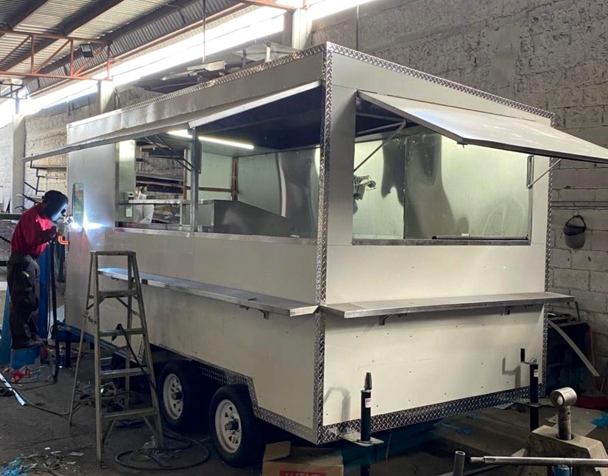 Food trailer tándem en fabricación con ventana de servicio abierta