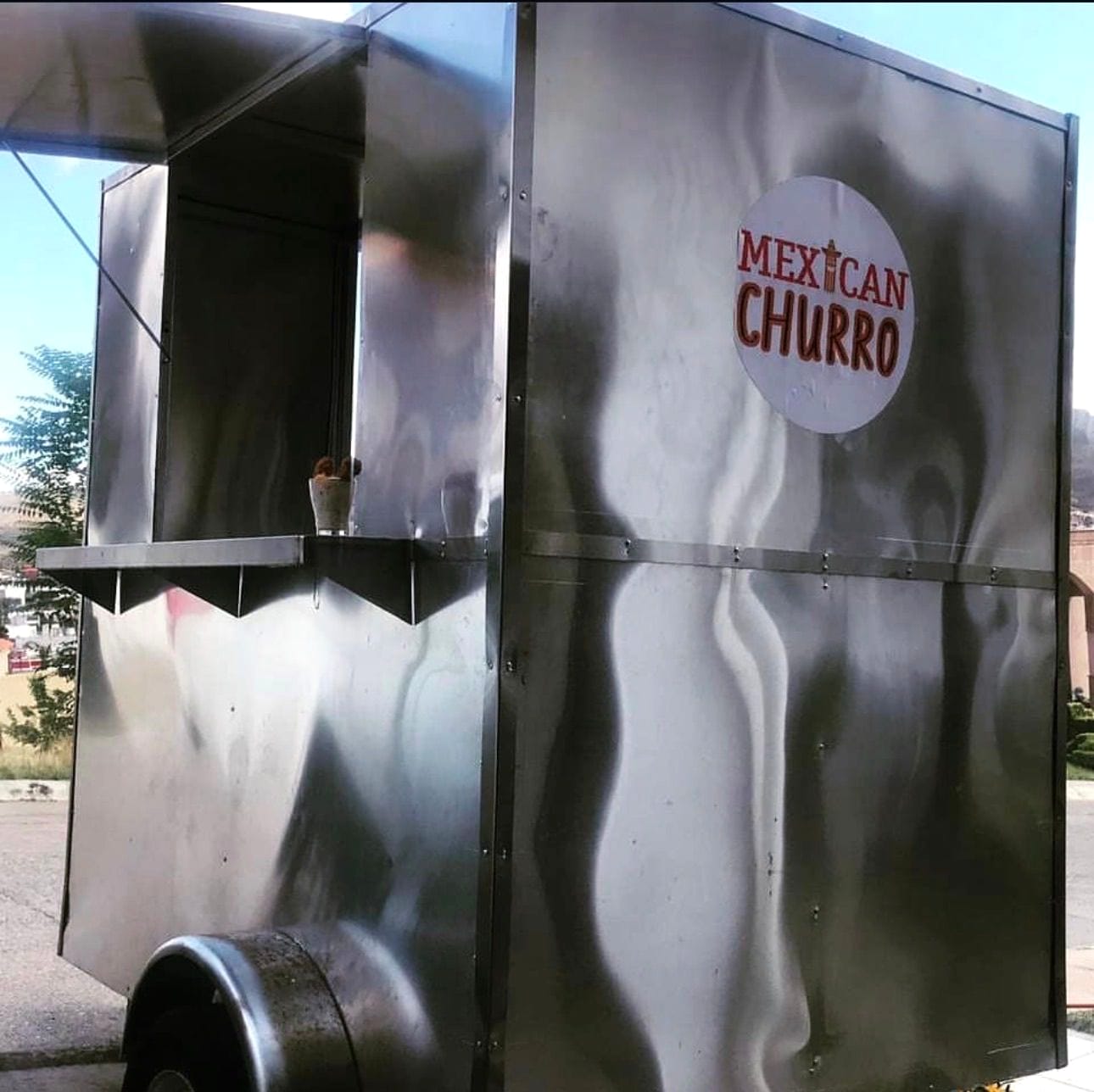 Food trailer compacto rotulado para un negocio de churros