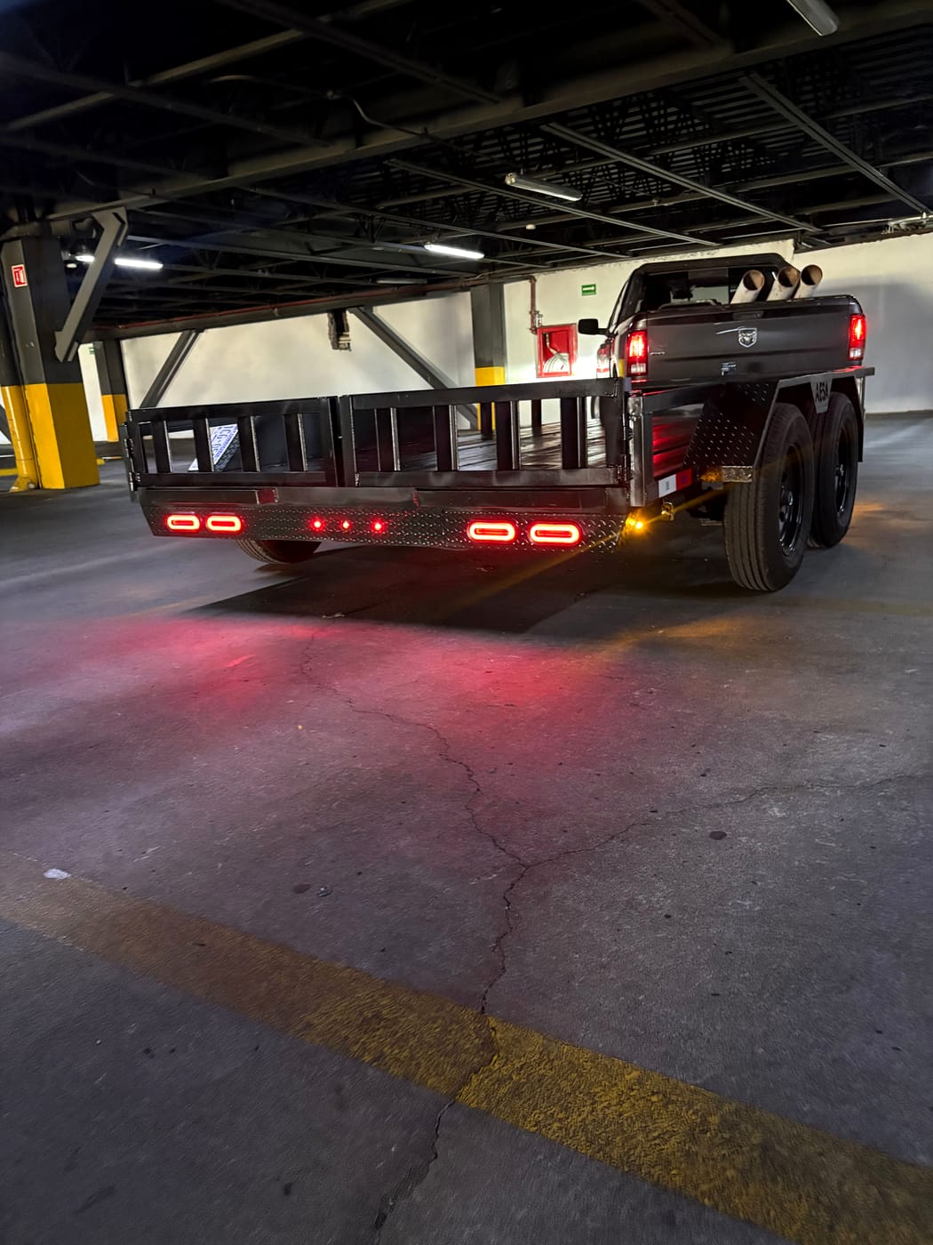 Remolque de plataforma enganchado a una pickup, vista trasera