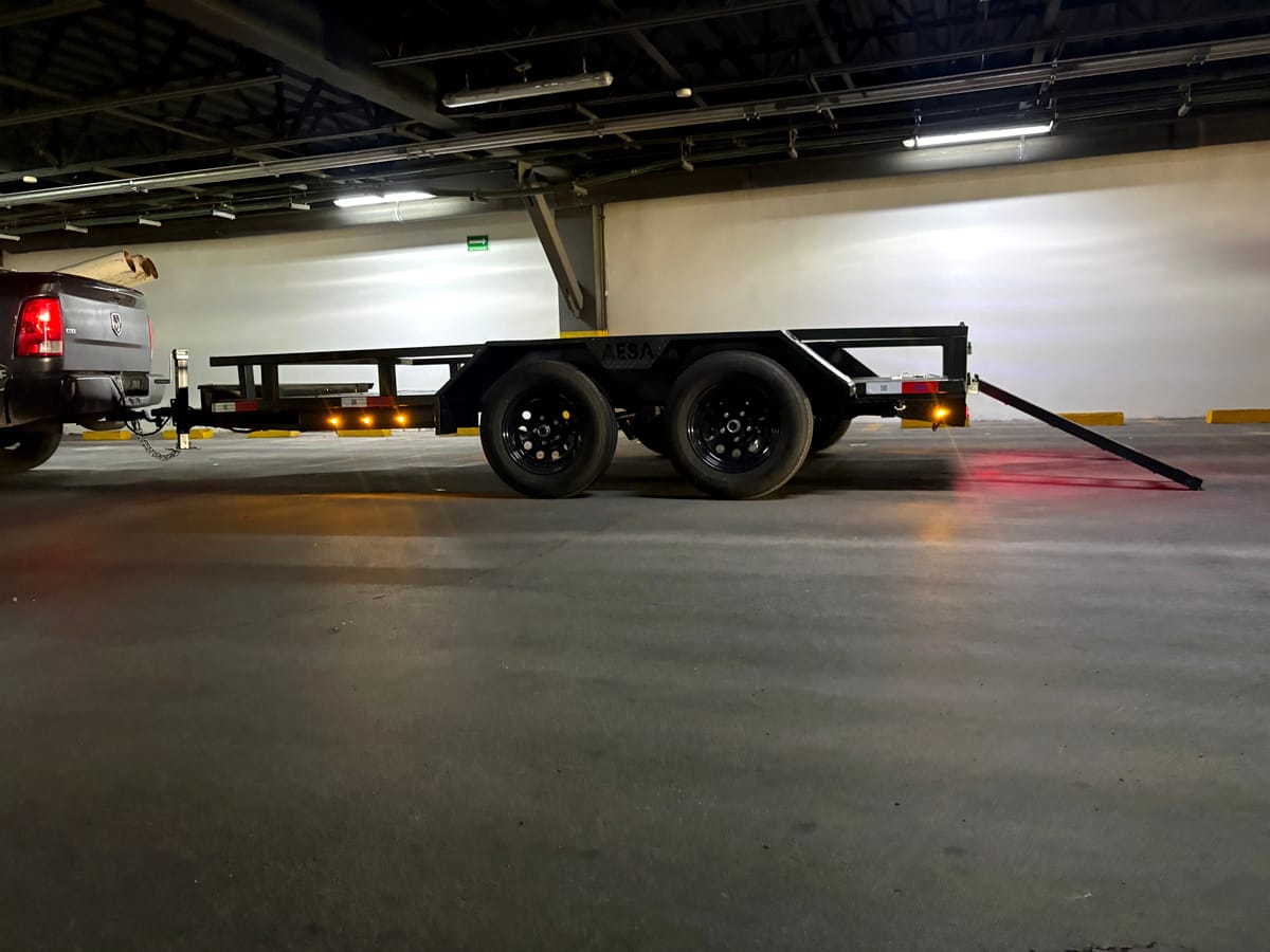 Remolque de plataforma negro con barandal y rampa trasera